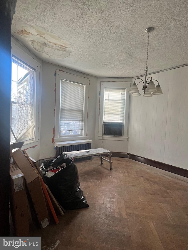 misc room with a chandelier and a textured ceiling