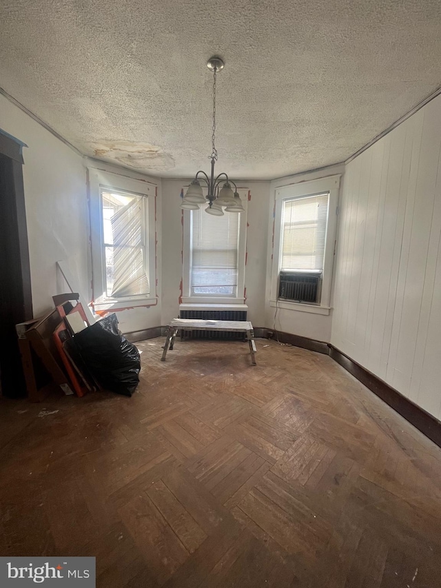 unfurnished dining area with a wealth of natural light, parquet floors, and a textured ceiling