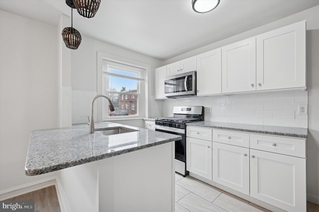 kitchen featuring sink, stainless steel appliances, white cabinets, and stone counters