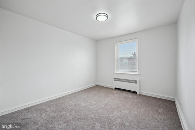 empty room featuring carpet floors and radiator heating unit