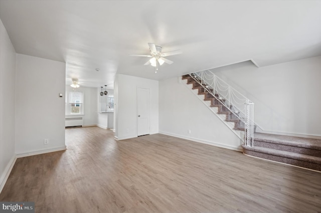 unfurnished living room featuring wood-type flooring and ceiling fan