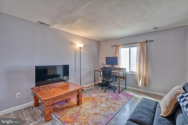 home office with light hardwood / wood-style floors