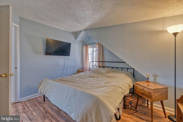 bedroom featuring hardwood / wood-style floors and a textured ceiling