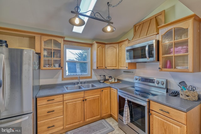 kitchen featuring stainless steel appliances, vaulted ceiling, sink, and decorative light fixtures