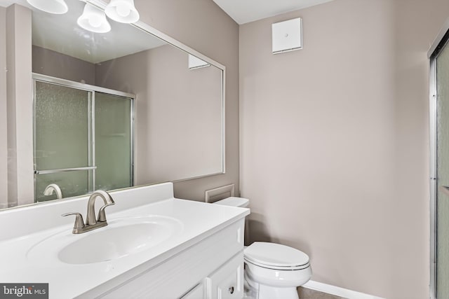 bathroom featuring vanity, walk in shower, and toilet