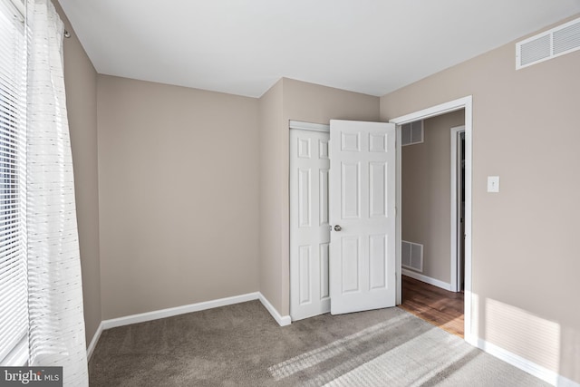 unfurnished bedroom featuring carpet floors and a closet