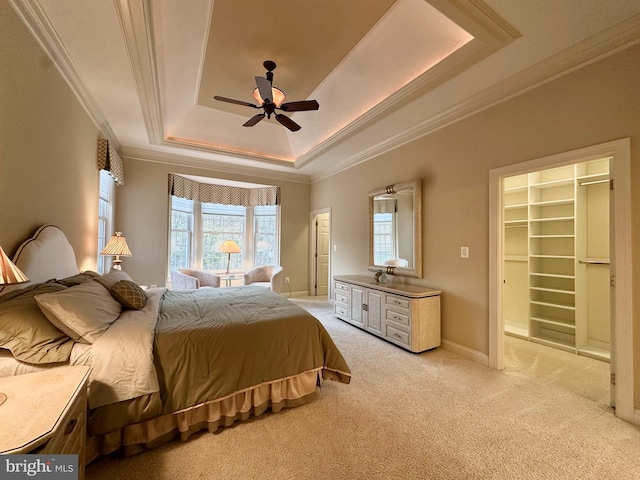 bedroom featuring ornamental molding, light carpet, and a tray ceiling