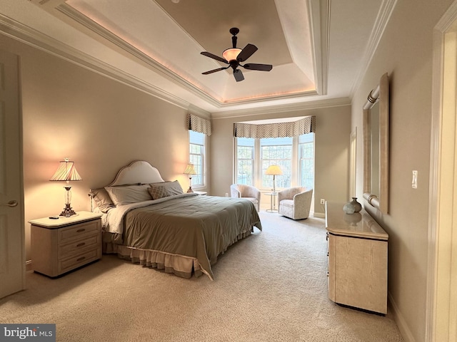 bedroom with crown molding, a tray ceiling, light colored carpet, and ceiling fan