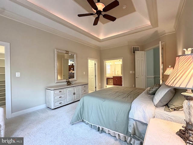 carpeted bedroom featuring ensuite bath, ceiling fan, a tray ceiling, ornamental molding, and a spacious closet