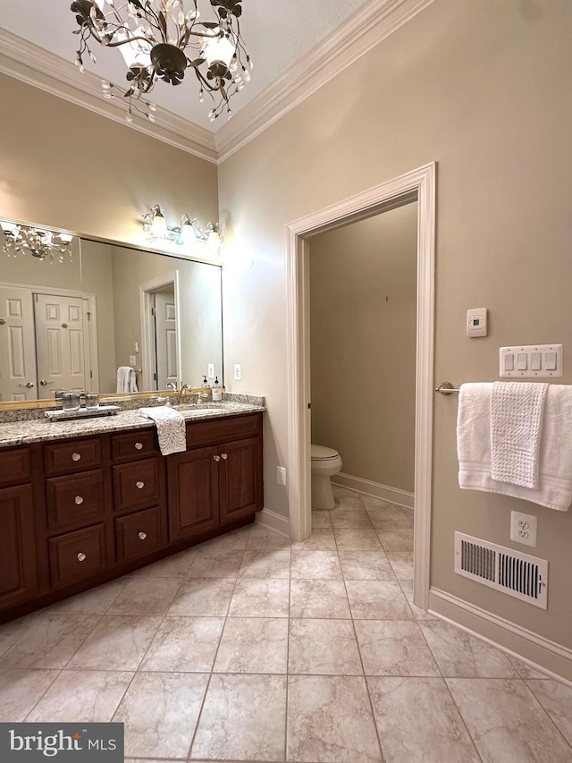 bathroom featuring ornamental molding, vanity, a chandelier, and toilet