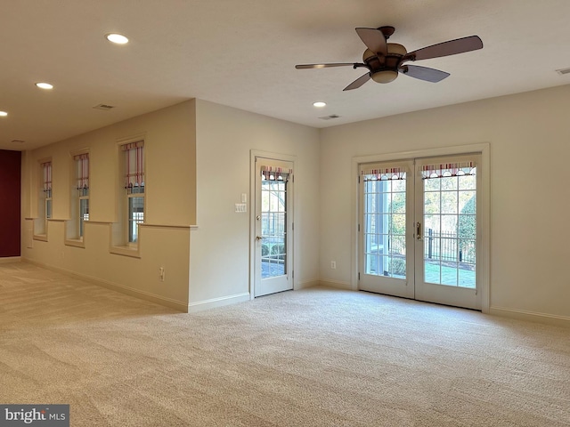 spare room with light carpet, ceiling fan, and french doors