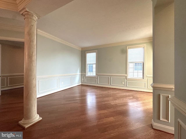 spare room featuring crown molding, wood-type flooring, and ornate columns