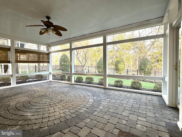 unfurnished sunroom featuring ceiling fan