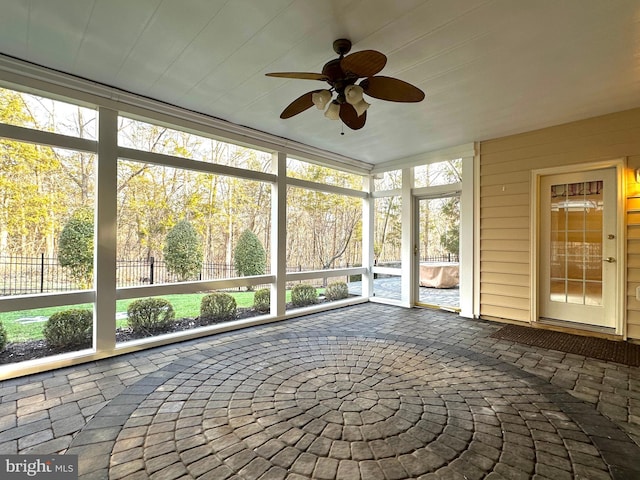 unfurnished sunroom featuring ceiling fan