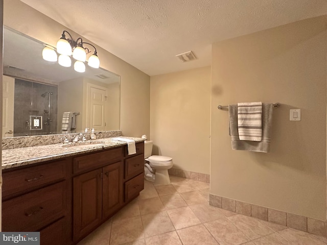 bathroom with tile patterned floors, vanity, a shower with shower door, and a textured ceiling