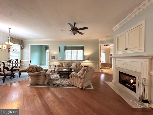 living room with a premium fireplace, wood-type flooring, a wealth of natural light, and crown molding