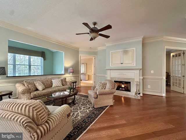 living room featuring hardwood / wood-style flooring, crown molding, and a high end fireplace