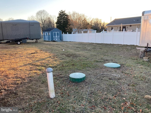 view of yard featuring a shed, fence, and an outdoor structure