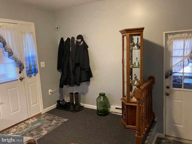 foyer with dark colored carpet, a baseboard radiator, and baseboards