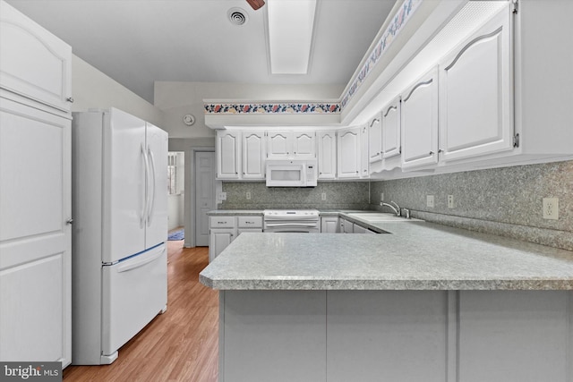 kitchen featuring white cabinetry, white appliances, kitchen peninsula, and sink