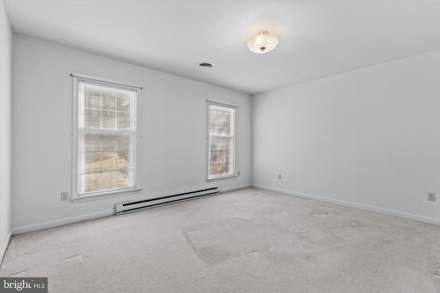 unfurnished room with light colored carpet and a baseboard heating unit