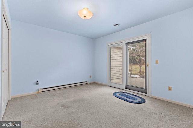 empty room with a baseboard heating unit and carpet flooring