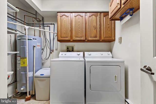 washroom with cabinets, electric water heater, and washing machine and clothes dryer