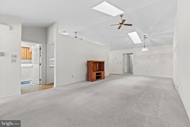 unfurnished living room with washer / clothes dryer, a skylight, light colored carpet, and ceiling fan