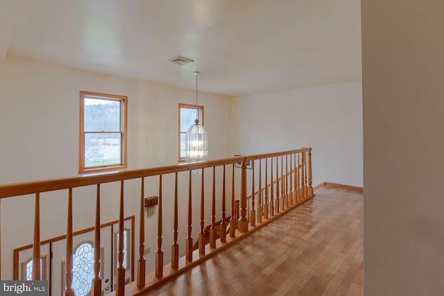 corridor featuring light hardwood / wood-style flooring and a chandelier