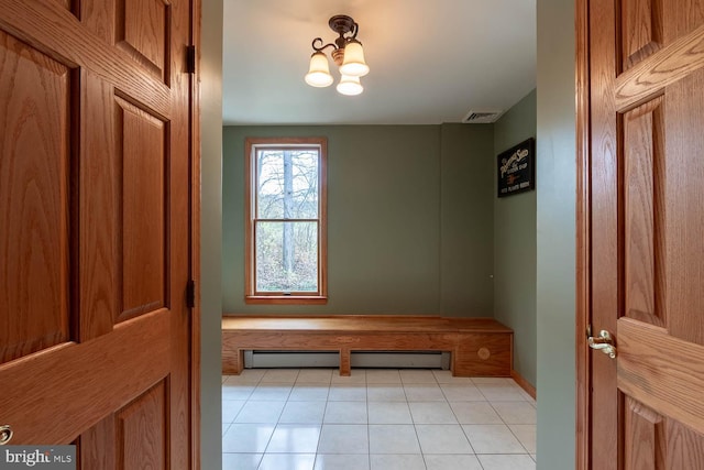 interior space featuring baseboard heating, a notable chandelier, and light tile patterned floors