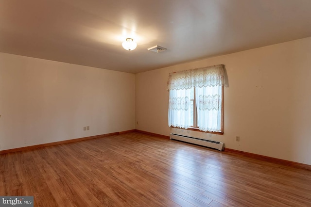 unfurnished room with hardwood / wood-style floors and a baseboard radiator