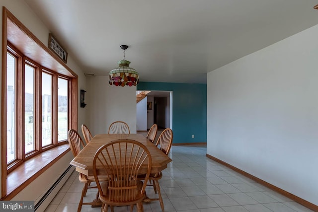 tiled dining room with a baseboard heating unit