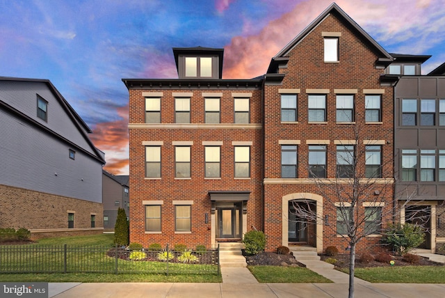 townhome / multi-family property with fence and brick siding