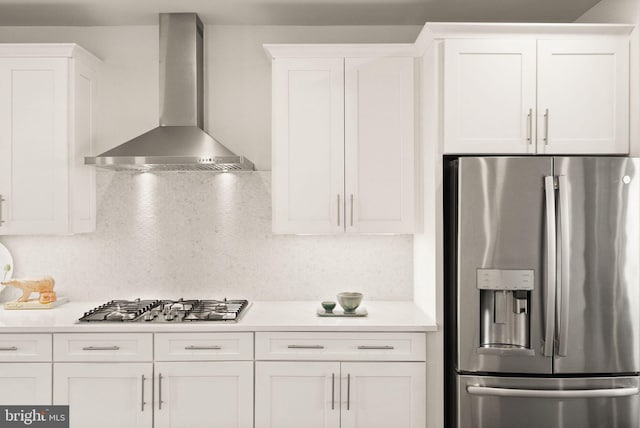 kitchen with white cabinetry, appliances with stainless steel finishes, and wall chimney exhaust hood