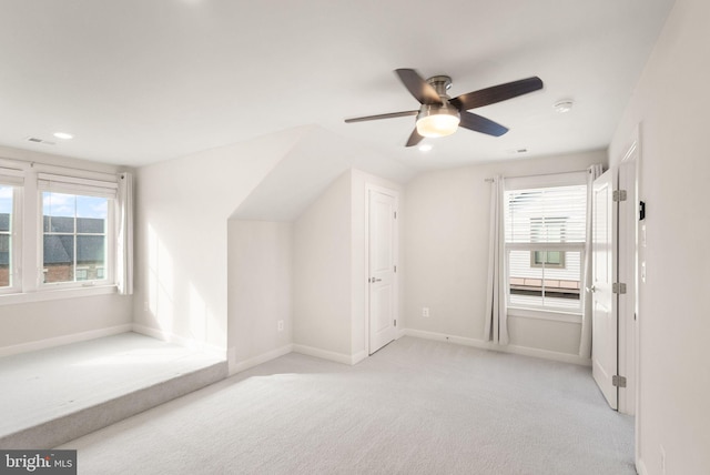 bonus room with a healthy amount of sunlight, light carpet, lofted ceiling, and ceiling fan