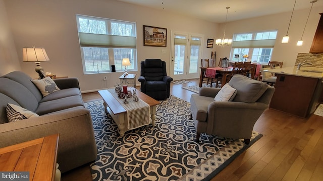 living room featuring dark wood-type flooring, an inviting chandelier, and sink