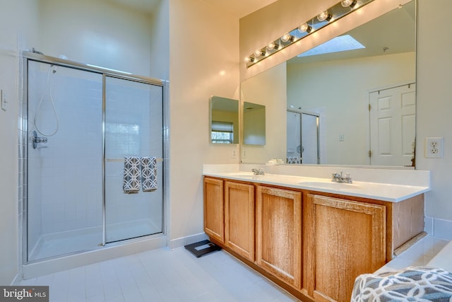 bathroom featuring an enclosed shower, vanity, and a skylight