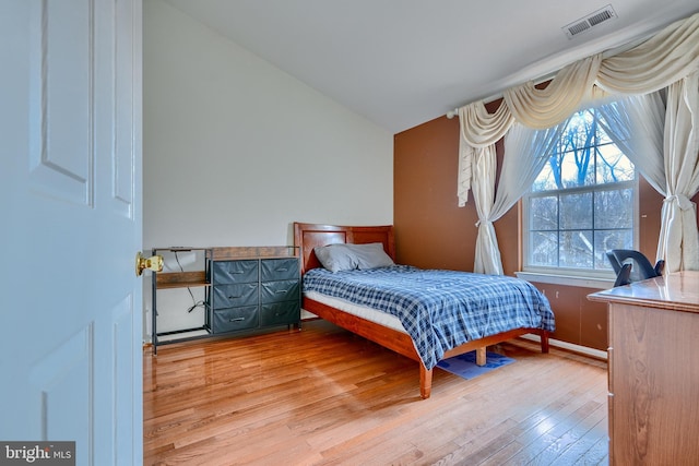 bedroom featuring light hardwood / wood-style floors and vaulted ceiling