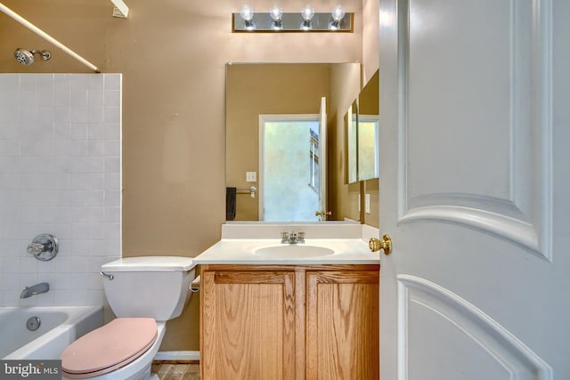 full bathroom featuring tiled shower / bath combo, vanity, and toilet