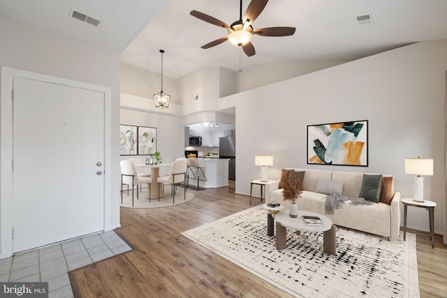 living room featuring ceiling fan, wood-type flooring, and high vaulted ceiling