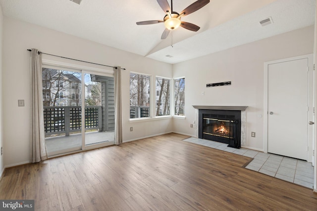 unfurnished living room with vaulted ceiling, light hardwood / wood-style floors, and ceiling fan