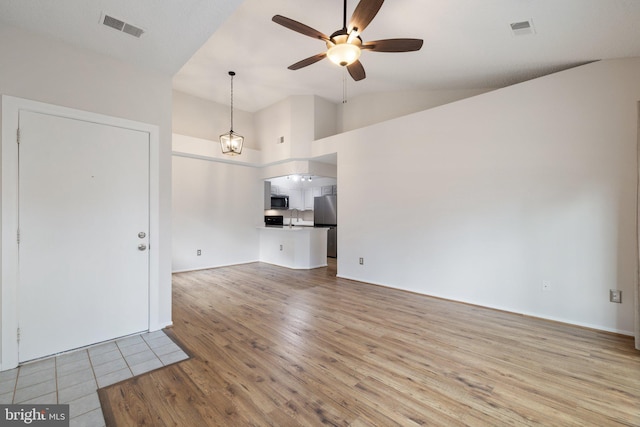 unfurnished living room featuring sink, high vaulted ceiling, light hardwood / wood-style floors, and ceiling fan