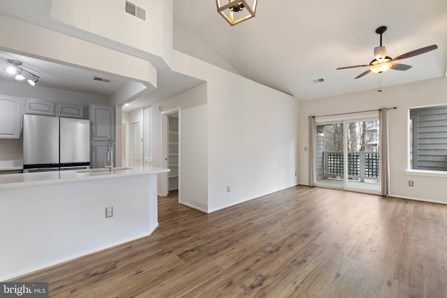 unfurnished living room featuring ceiling fan, lofted ceiling, dark hardwood / wood-style floors, and sink