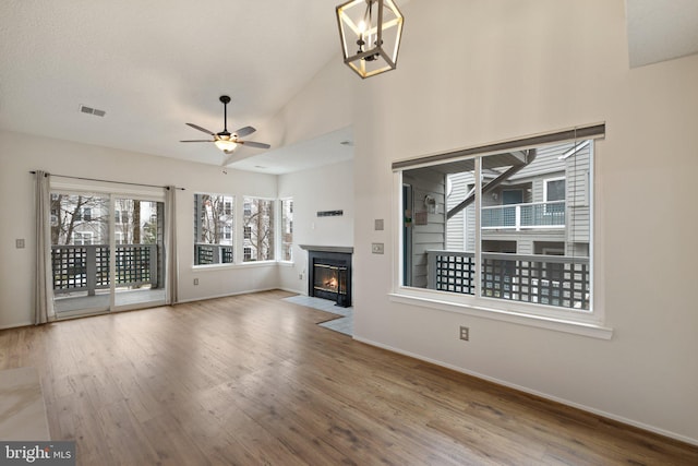 unfurnished living room featuring hardwood / wood-style flooring, high vaulted ceiling, and ceiling fan