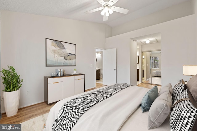 bedroom featuring vaulted ceiling, connected bathroom, and light hardwood / wood-style flooring