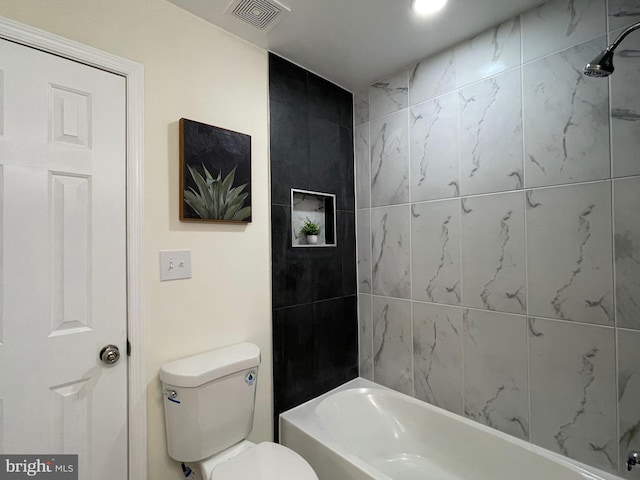 bathroom with toilet and tiled shower / bath combo