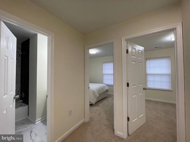 hallway featuring light colored carpet