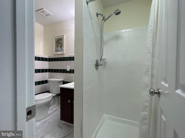 bathroom with curtained shower, toilet, tile walls, and vanity