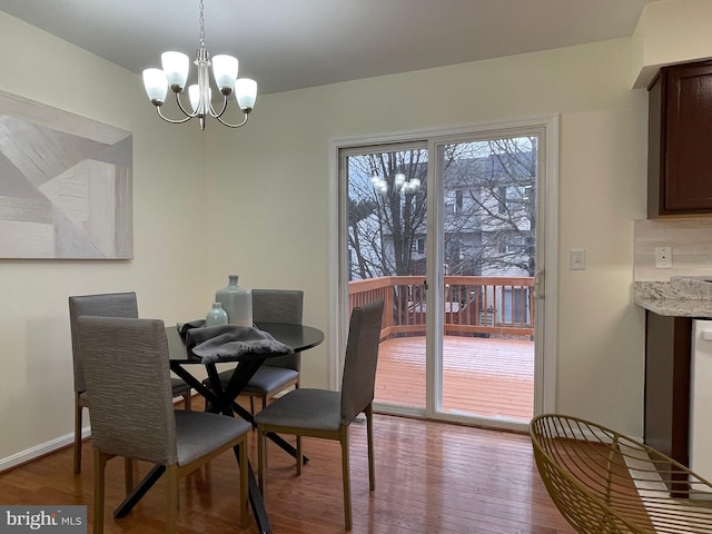 dining space featuring light wood-type flooring and a notable chandelier