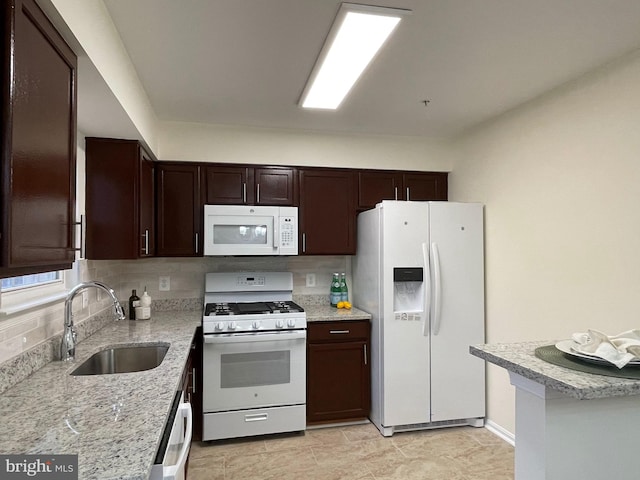 kitchen with sink, decorative backsplash, white appliances, and light stone counters